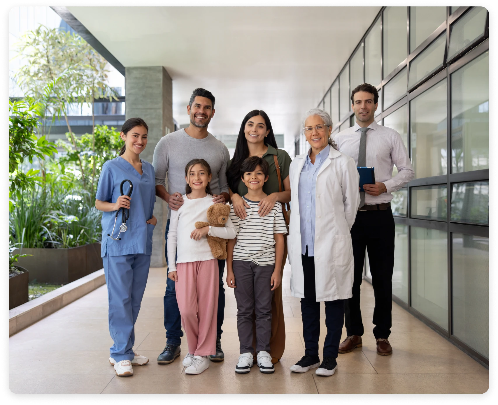 Healthcare team with family in hospital corridor